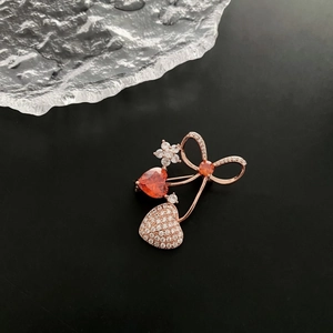 Elegant rose gold heart brooch with red zircon and sparkling crystals on grey background
