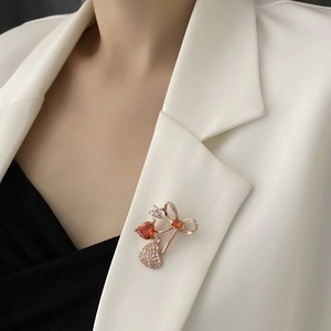 Elegant cherry-shaped brooch with red heart stones and crystals on white suit lapel