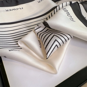 Detailed texture of black and white silk scarf with FLOWER print and striped patterns