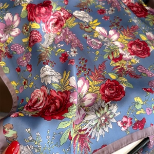 Detailed close-up of French rose print on blue silk scarf showing satin texture