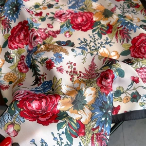 Close-up of vintage floral print silk scarf featuring red roses and satin texture
