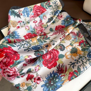 Detailed view of french rose floral silk scarf showing soft satin texture and black hem