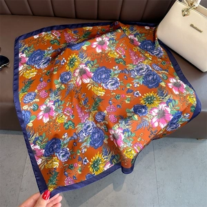 Detail of vintage floral silk scarf featuring intricate rose patterns and navy rolled edges