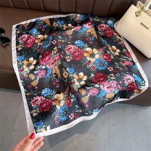 Detail of vintage floral silk scarf with red roses on black base and satin border