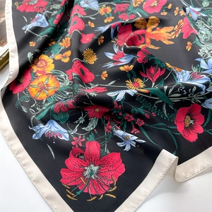 Detailed view of floral silk scarf featuring vibrant poppy and lily prints on black silk