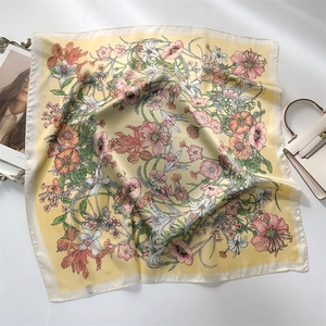 Close-up of a 70cm yellow floral satin square scarf with a smooth and glossy texture