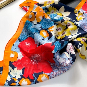 Detailed close-up showing the smooth texture and floral pattern of the satin neck scarf