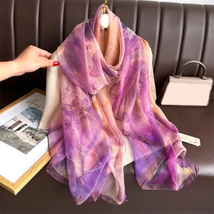 Purple and orange gradient silk scarf elegantly draped on a mannequin in a stylish setting