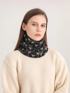 Close-up of a warm black knitted neck gaiter with a cute beige bear pattern for winter