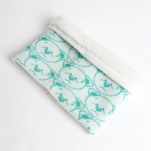 Detail of teal bear pattern knit scarf with white soft faux fleece lining texture