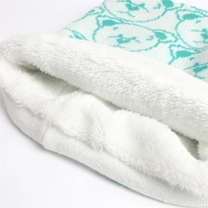 Detailed macro view of mint green knit scarf with bear patterns and soft fleece lining