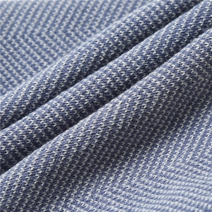 Close-up of thick blue and white herringbone knit fabric with soft texture and patterns