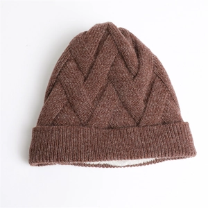 Detailansicht der dunkelbraunen Strickmütze mit Textur und warmem weißem Fleece-Innenfutter