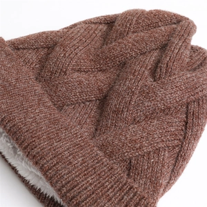 Detailaufnahme der karamellfarbenen Strickmütze mit Zopfmuster und warmem Fleecefutter