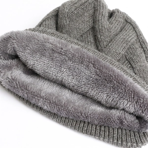 Detail der grauen Strickmütze mit dickem Fleece-Futter und Zopfmuster-Struktur