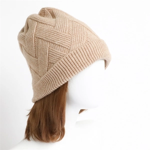 Detailaufnahme der beigen Strickmütze mit diagonalem Muster und geripptem Saum