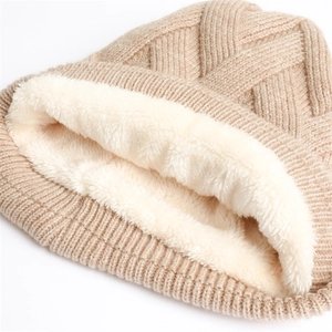 Detail der beige gestrickten Mütze mit dickem weißem Fleecefutter für Wärme