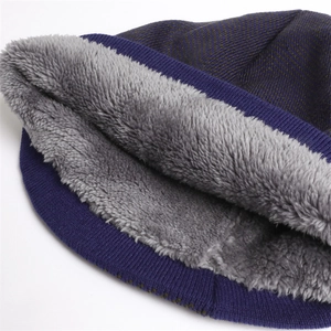 Detail of warm winter knit hat with purple herringbone pattern and thick grey fleece lining