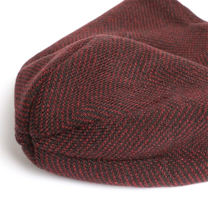 Macro shot of thick herringbone knit texture in black and deep red yarn blend