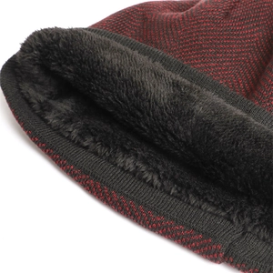 Detail of red and black knit beanie featuring warm black fleece lining and ribbed edge