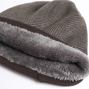 Detail of herringbone knit texture and thick faux fur lining on winter beanie hat