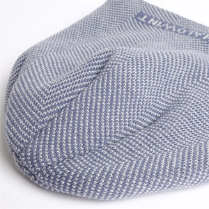 Macro shot of blue herringbone knit texture and VALDWINT jacquard logo detail
