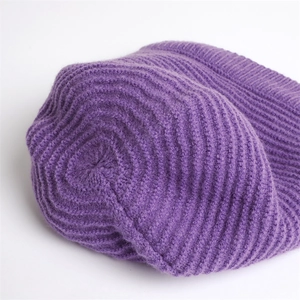 Detailed macro view of purple knitted beanie showing thick ribbed stitch and fuzzy texture
