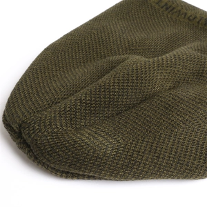 Detail of olive green knit beanie showing thick chevron texture and WINTER stitching