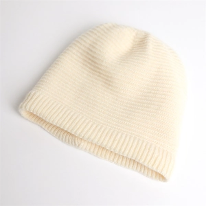 Detailed view of the soft ribbed knit texture and thick cream wool fabric of the beanie