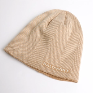 Detailed knit texture of light brown beanie with white chevron pattern and Halowint text