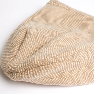 Detailed close-up of knit herringbone pattern and soft fiber texture in beige
