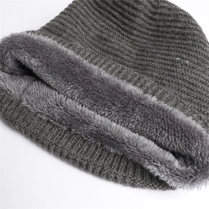 Detailed view of dark grey knitted beanie with thick faux fur lining for winter warmth