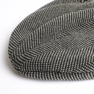 Close-up of thick grey herringbone knit texture and warm weave details on the beanie hat