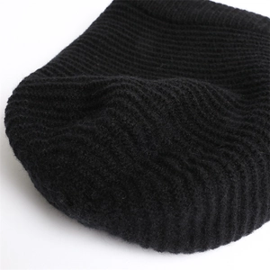 Detailed close-up of black ribbed knit beanie showing thick texture and warm fleece material