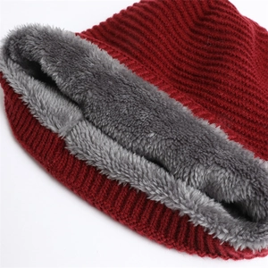 Close-up of thick red knitted hat featuring a plush grey fleece lining for winter warmth