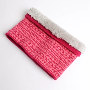 Dettaglio di uno scaldacollo in maglia spessa con motivo rosa e morbida fodera in pile