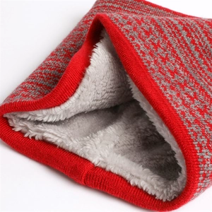 Dettaglio dello scaldacollo in maglia rossa con calda fodera in pile bianco spesso