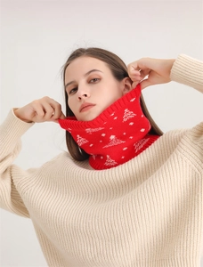 Detail of red knit neck warmer featuring white Christmas tree and snowflake patterns