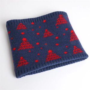Close-up of winter knit neck warmer with red Christmas tree pattern on navy blue wool