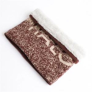 Detail of warm winter neck warmer with brown jacquard knit and white faux fur lining