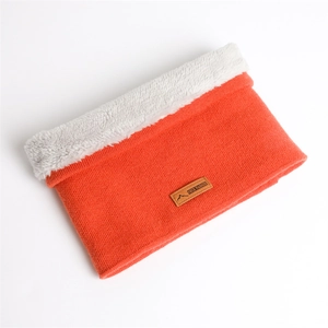Détail d'un tour de cou en tricot orange avec doublure polaire grise et écusson cuir