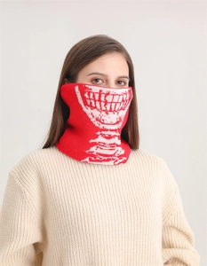 Dettaglio dello scaldacollo in maglia rossa con motivo a denti di teschio intrecciati