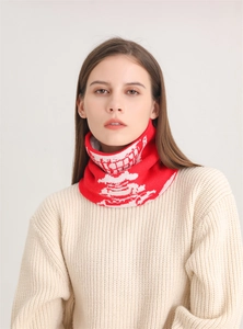 Dettaglio dello scaldacollo in maglia rosso e bianco con motivo a denti e consistenza spessa