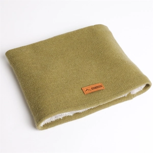 Détail du cache-col en tricot vert olive avec doublure polaire et écusson en cuir