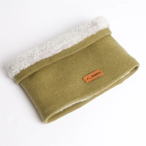 Détail du cache-col en tricot vert olive avec doublure polaire blanche et écusson en cuir