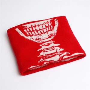 Dettaglio dello scaldacollo in maglia rossa con trama a motivi di teschio in jacquard