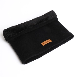 Gros plan sur tour de cou en tricot noir avec doublure polaire et écusson en cuir