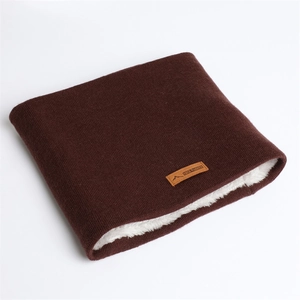 Détail d'un tour de cou en tricot marron foncé avec doublure polaire blanche et écusson