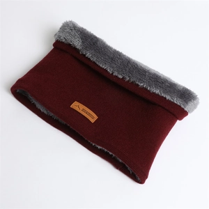Détail du cache-col en tricot avec doublure épaisse en polaire grise et écusson en cuir