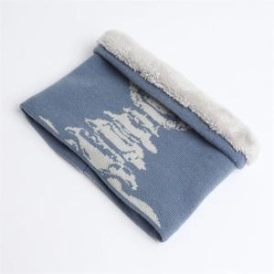 Dettaglio dello scaldacollo in maglia blu con motivi bianchi e fodera in pelliccia sintetica